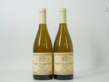 deux bouteilles de vin posées l'une à côté de l'autre sur une surface blanche