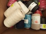 many balls of yarn in a box on the floor
