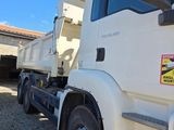 a white dump truck parked in front of a building