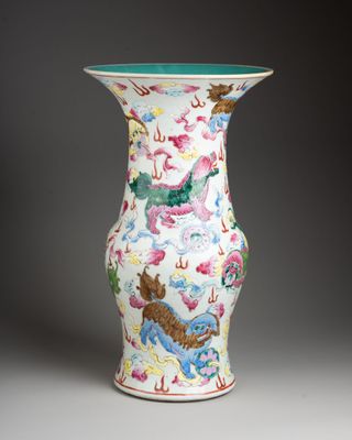 un vase blanc orné de motifs colorés sur un fond gris