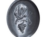 a silver plate with a flower and grapes design on it