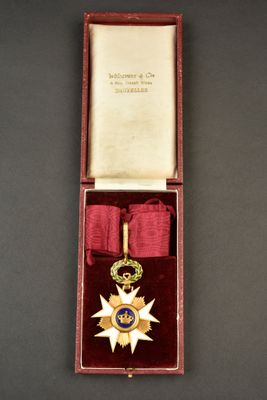 une image représentant une médaille dans un coffret rouge orné d'un ruban