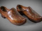 pair of wooden clogs with carved design on them