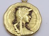a close up of a gold coin with a woman ' s face on it