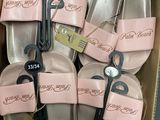six paires de chaussons roses dans une boîte en carton