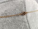 a close up of a gold chain bracelet with a heart on it