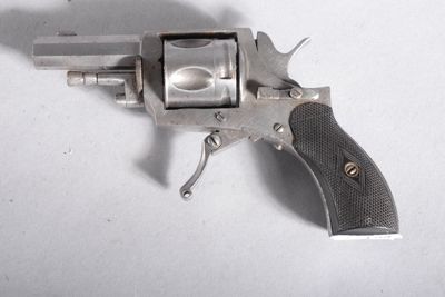 un pistolet posé sur une surface blanche