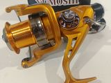 a close up of a fishing reel on a table near a box