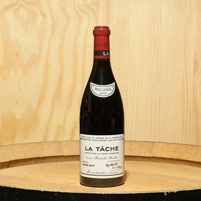 a bottle of wine sitting on top of a barrel
