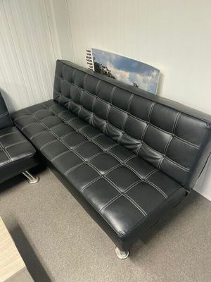 un canapé en cuir noir et un fauteuil dans un salon