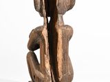 wooden sculpture of a man and woman sitting on a bench