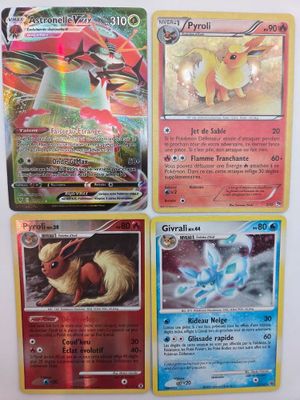 Quatre cartes Pokémon sont posées sur une table avec un fond blanc.