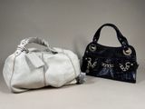 pair of black and white purses with tags on them