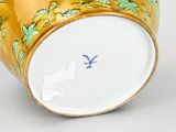a close up of a yellow vase with a blue bird on it