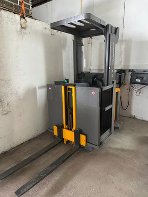 un chariot élévateur dans un garage, avec un mur en arrière-plan