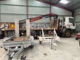 a truck with a crane in a building with other trucks