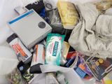 a white bag filled with various items and a cell phone