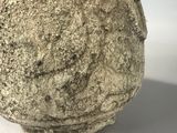 sculpture of a stone head on a white surface