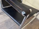 a black leather chair with a metal frame and a black seat