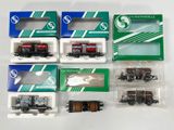 six coffrets de trains miniatures différents, présentés dans des emballages en plastique sur un fond blanc