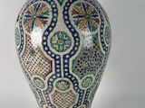 a vase with a lid sitting next to a smaller vase