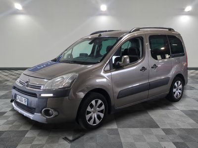 La camionnette argentée est garée sur un sol à damier dans un garage.
