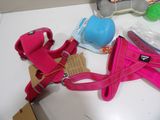 a pink dog harness on a table with other items on it