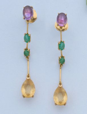 une photo d'une paire de boucles d'oreilles en or ornées de pierres vertes et violettes