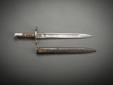 a close up of a knife on a table next to a knife on a table