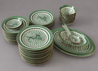 plusieurs assiettes et bols verts et blancs posés sur une surface grise