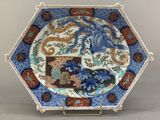a close up of a plate on a stand with a dragon on it