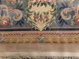 a picture of a rug with a vase of flowers on it