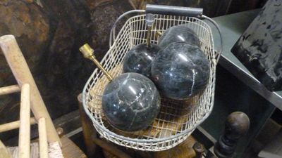 un panier rempli de balles posé sur une table en bois