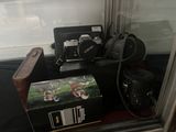 une photo montrant une valise, un appareil photo et d'autres objets dans une vitrine