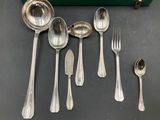 five silver spoons and two silver spoons on a table