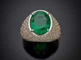 a close up of a ring with a green stone in it