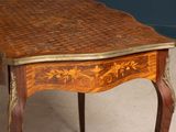 a small table with a wooden top on a carpeted floor