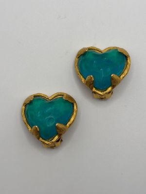 two gold and turquoise heart shaped earrings on a white surface