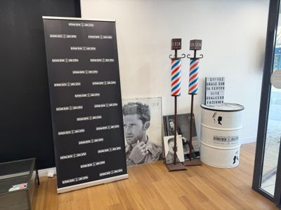 une photo d'un salon de coiffure avec une enseigne et un poteau de coiffeur