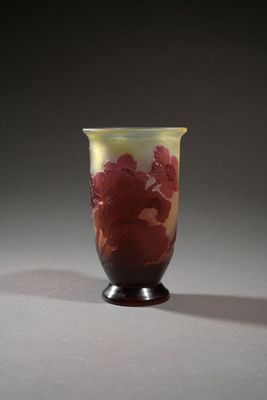 vase with red flowers on a black base on a gray background