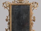 une image représentant un miroir à cadre doré posé sur un pied, avec la photo d'un homme