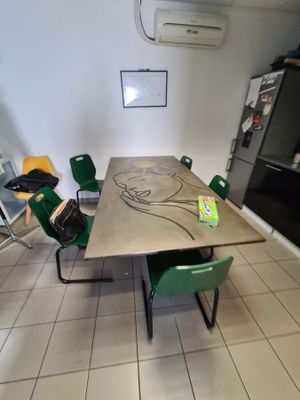 a table and chairs in a room with a refrigerator