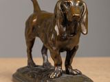 bronze statue of a dog on a base on a wooden table