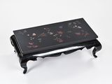 une photo d'une petite table noire sur laquelle sont disposées des fleurs