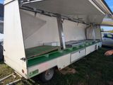a man standing next to a truck with a table inside of it