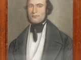 portrait of a man in a suit and bow tie in a wooden frame