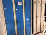 trois casiers bleus dans une pièce au sol carrelé de blanc