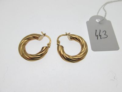 a pair of gold hoop earrings with a price tag