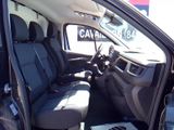 the interior of a car with the door open and a laptop on the floor