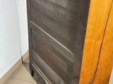 a wooden dresser with a black top on a tiled floor